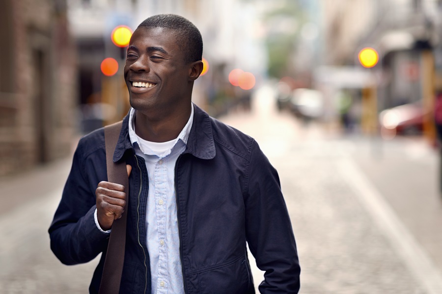 Man smiling while walking down the street 