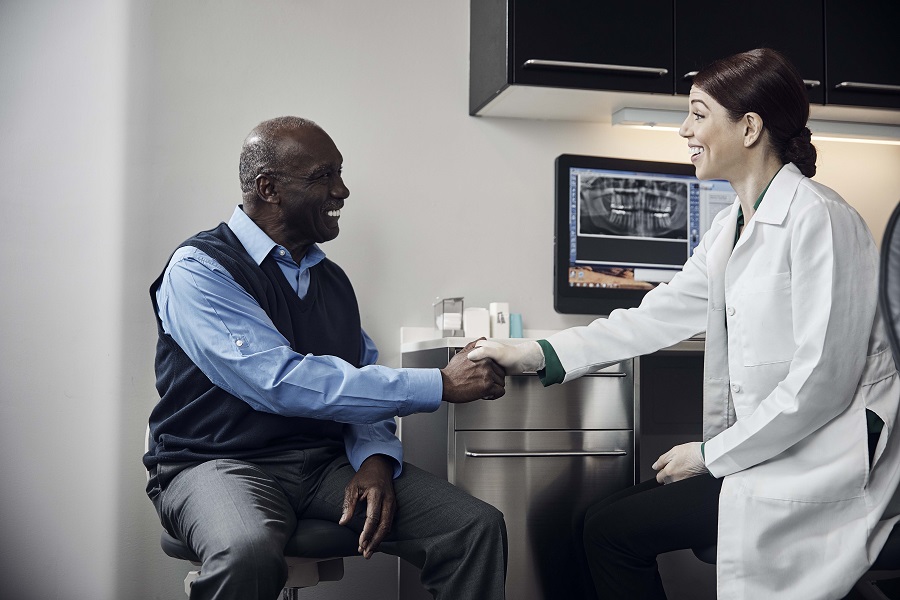 Male patient shaking dentists hand